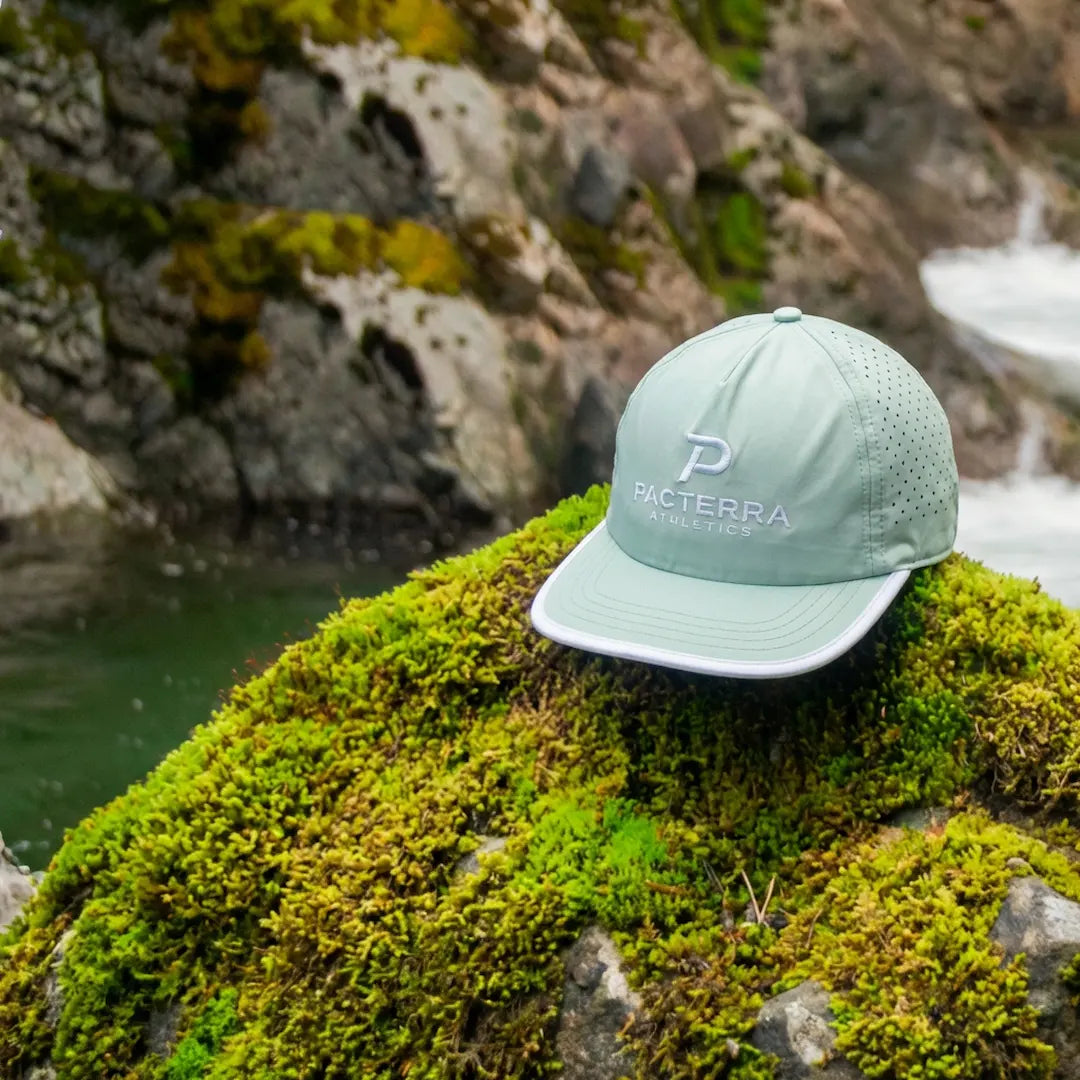 Sea Foam All Day Hat resting outdoors on moss-covered rock