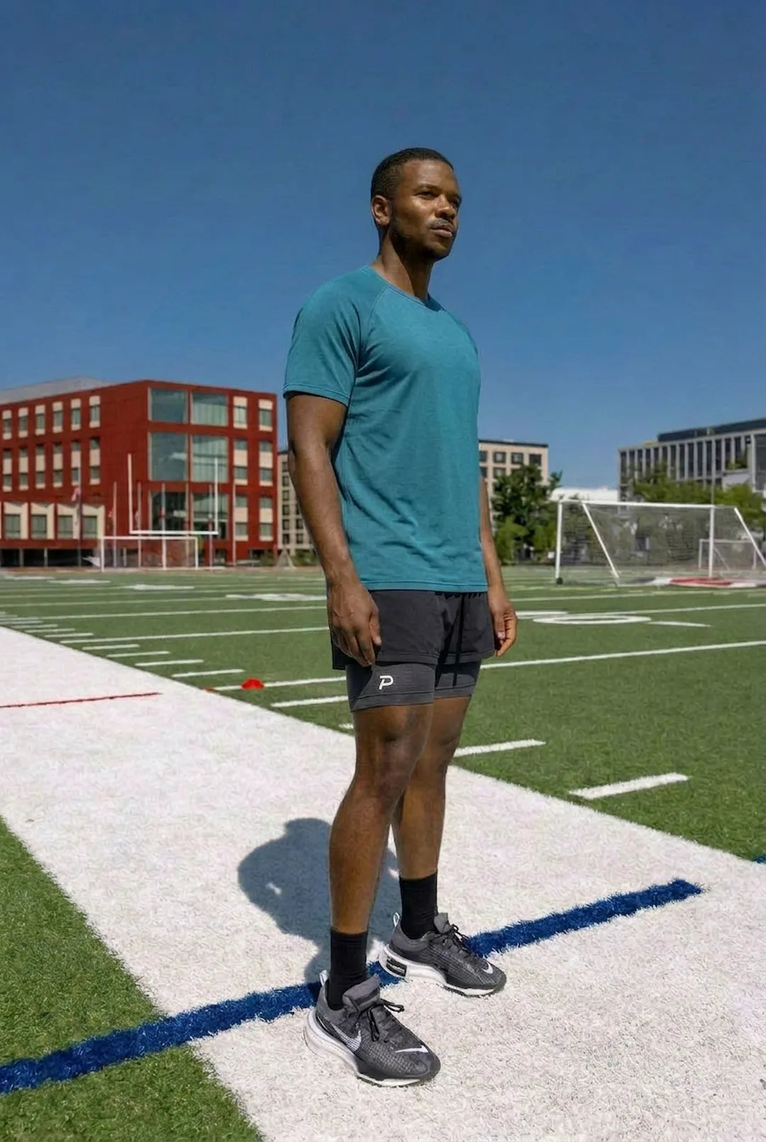 Male athlete wearing The Draper Tee in teal with The Middy compression shorts, showcasing the modern athletic fit and everyday versatility.