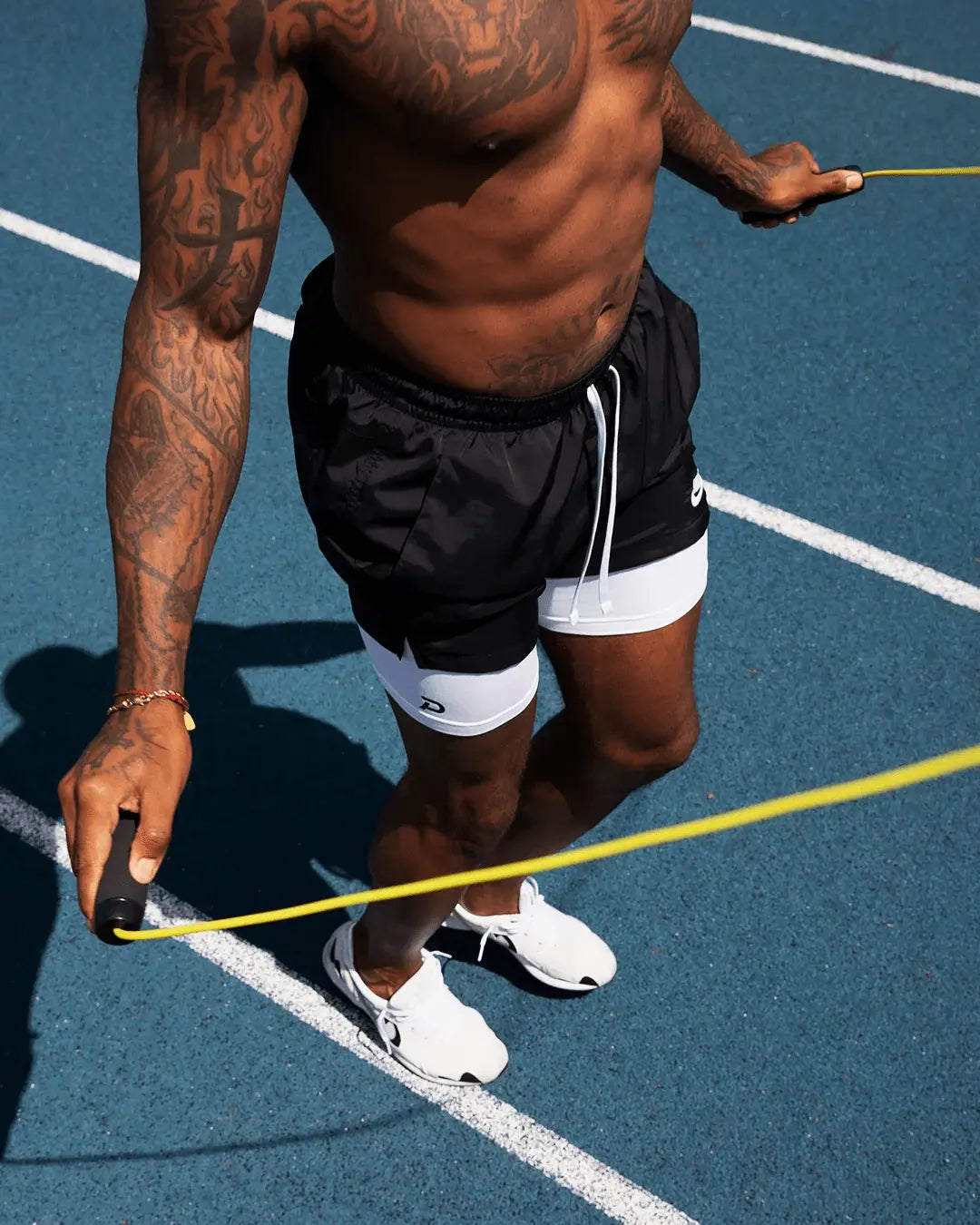 Athlete jumping rope in white Middy compression shorts, showing the stay-put leg bands and comfort during vertical movement.