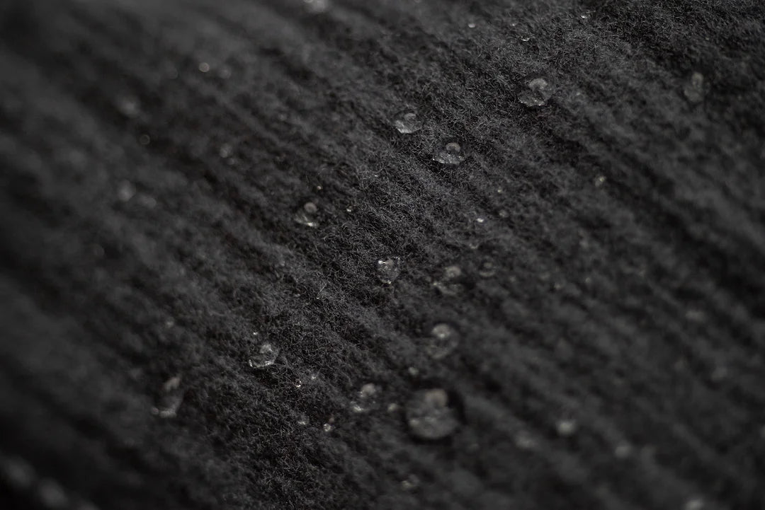 Close-up of water beading on Pacterra SwingLoft fabric highlighting moisture-wicking and high-performance compression tech.