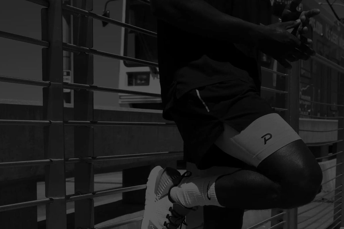 Athletic man wearing black Pacterra compression shorts with a secure phone pocket for high-intensity training.