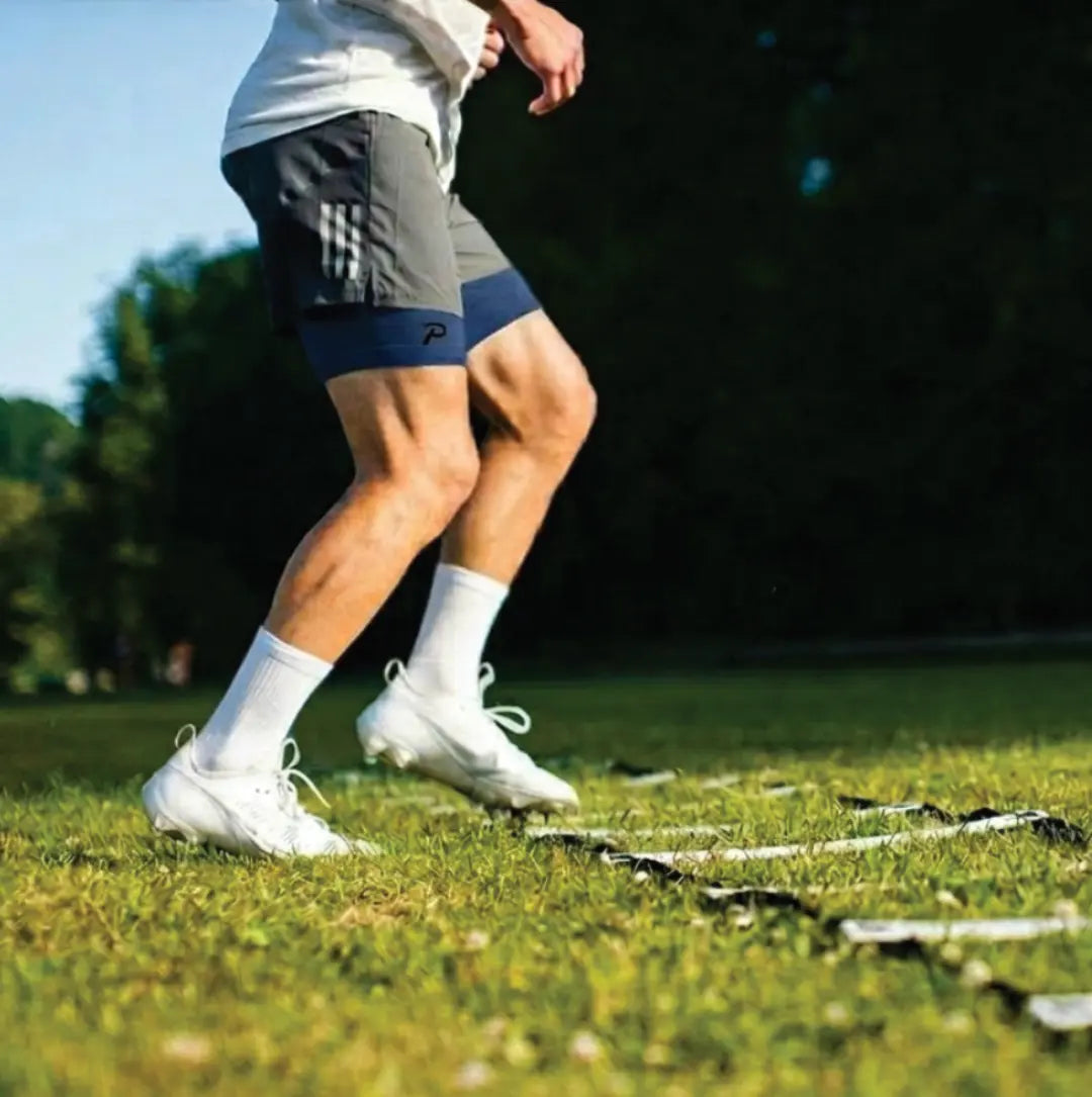 Close-up of an athlete performing agility ladder drills in navy Pacterra compression shorts, highlighting the durability and flexibility of the SwingLoft fabric under stress.