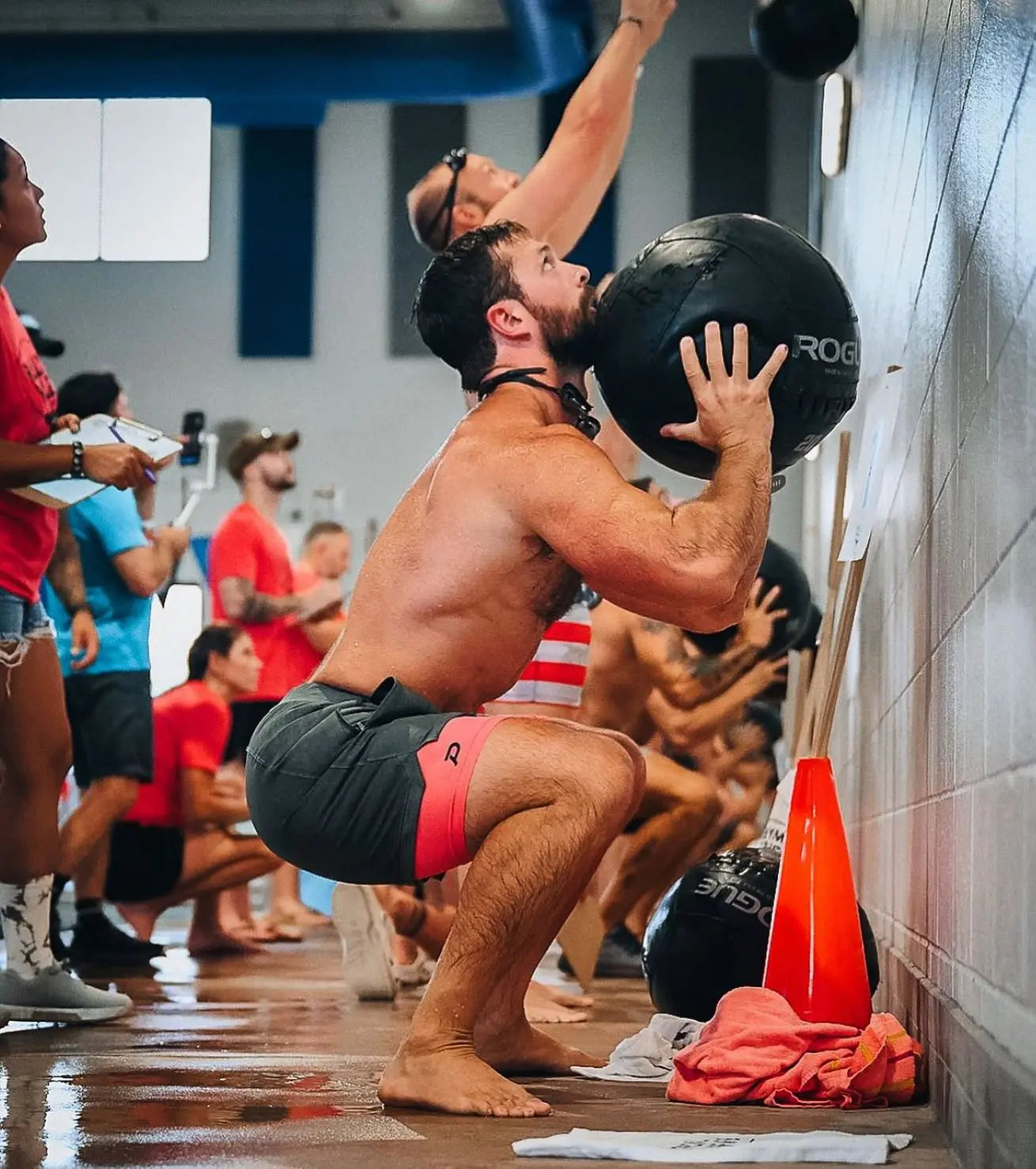 Athlete performing medicine ball slams in pink compression shorts, demonstrating the durability of the performance fabric.