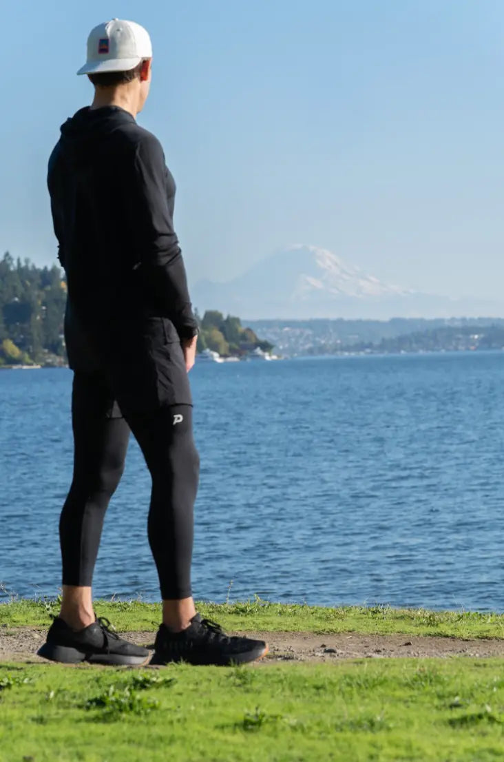 Full-length view of an athlete in black Strider tights, the ultimate men's comfort compression base layer for outdoor performance.