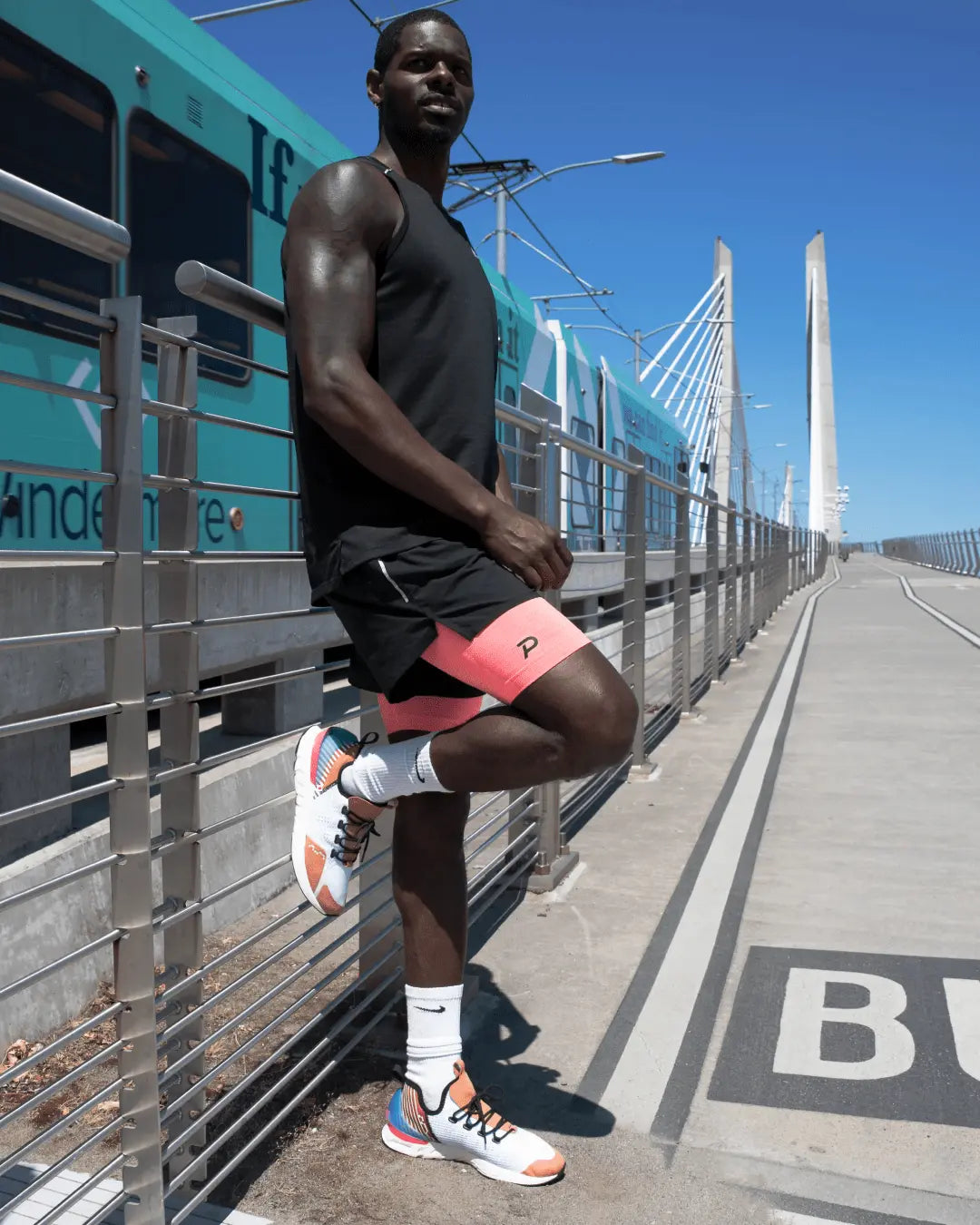 Urban athlete posing in pink Pacterra shorts layered under gym shorts for a versatile training outfit.