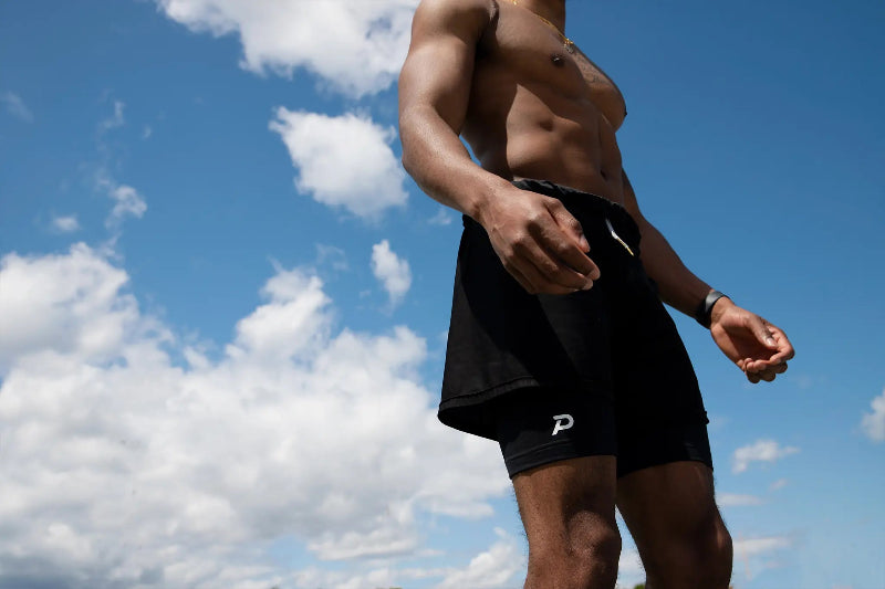 Low-angle view of an athlete wearing Pacterra Middy compression shorts as a high-performance base layer for muscle support