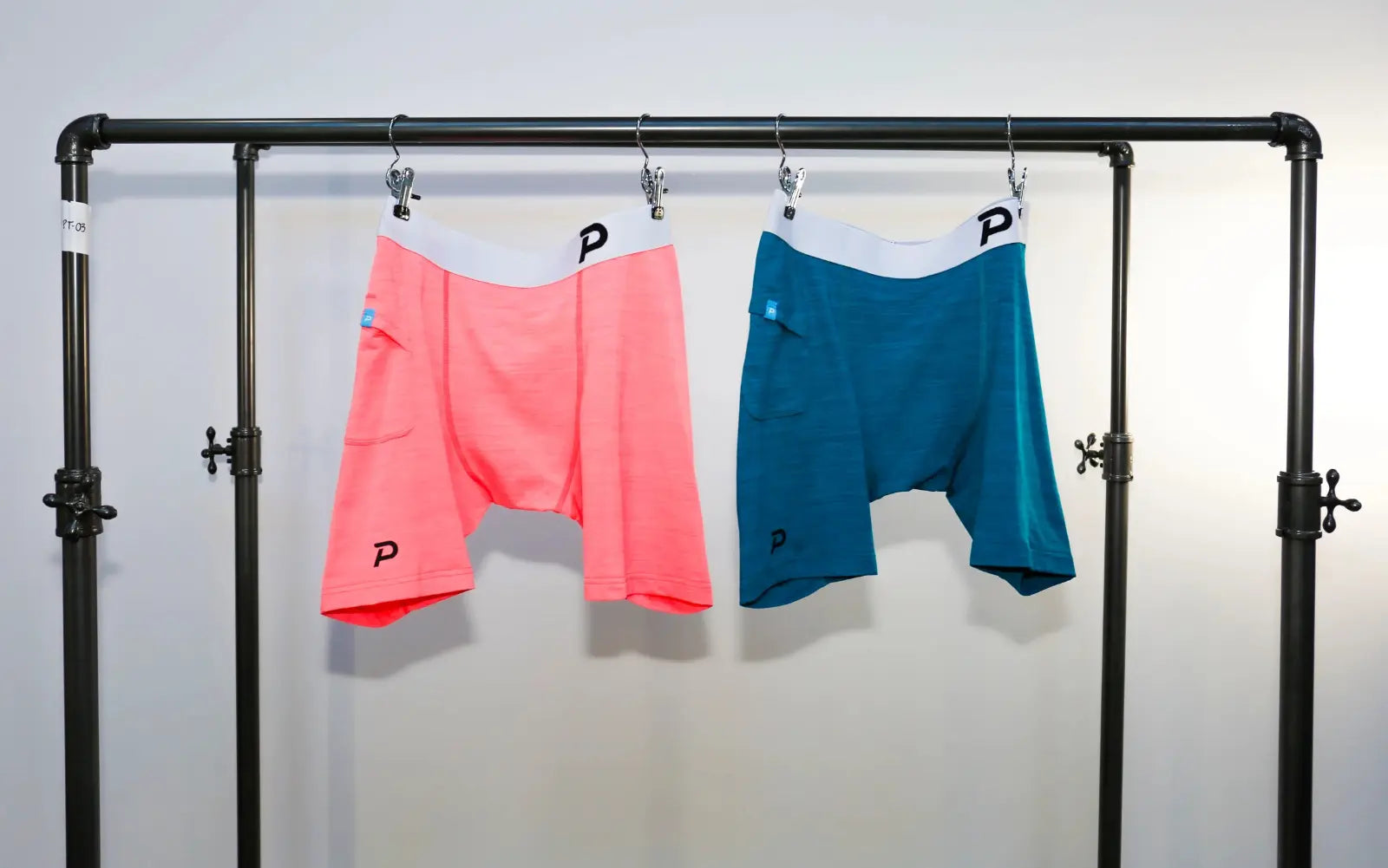 Close-up view of Pacterra Middy men's compression shorts on a rack highlighting the integrated side smartphone pocket.