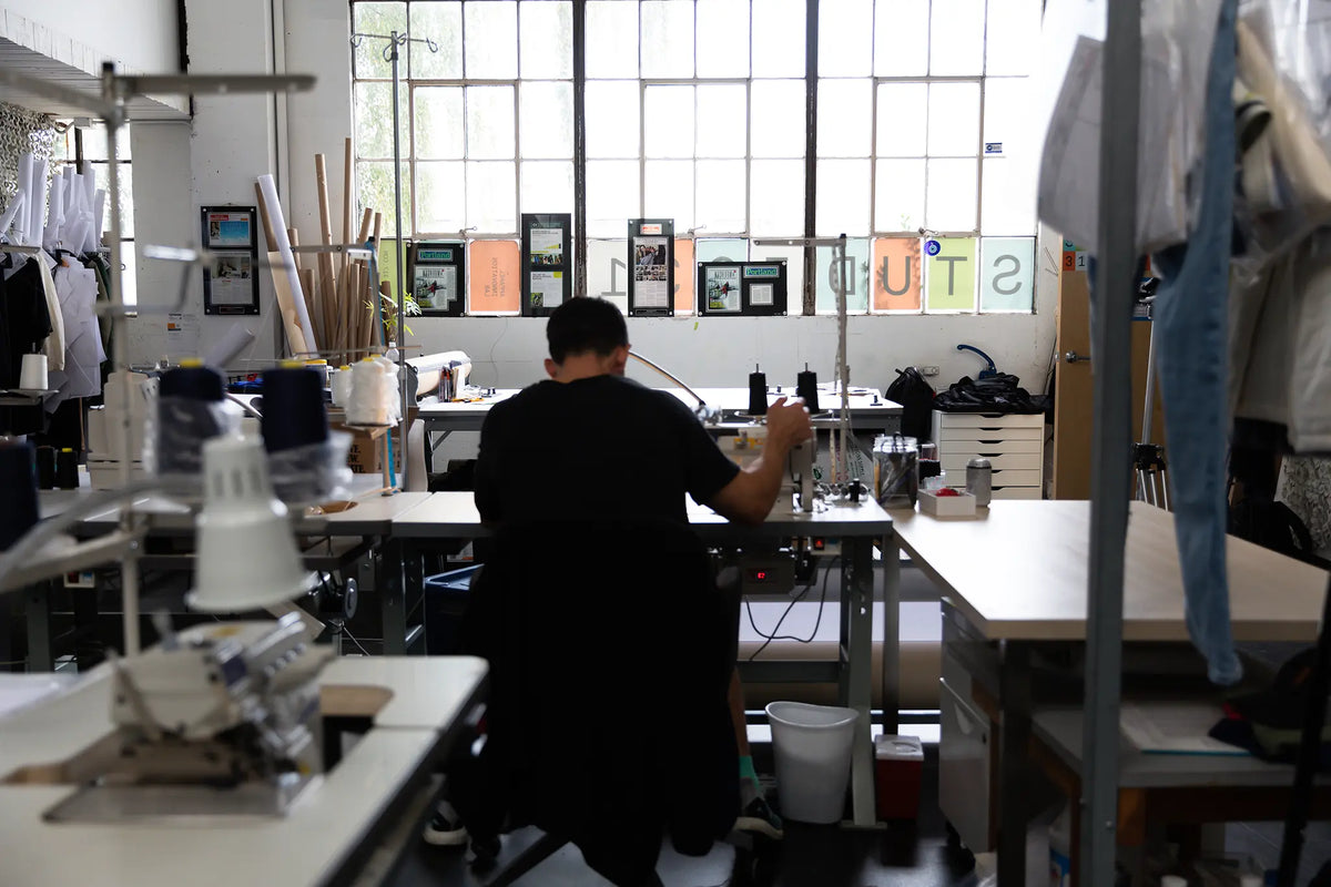 Pacterra Athletics founder Aaron Prosser at a sewing machine in the Portland design studio, hand-crafting high-performance men's compression short prototype