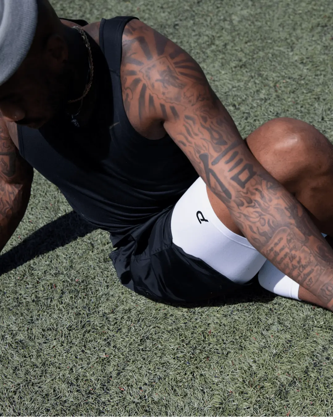 Athlete wearing white Pacterra Middy compression shorts for an outdoor turf workout, highlighting the most comfortable men's performance base layer for agility and field sports.