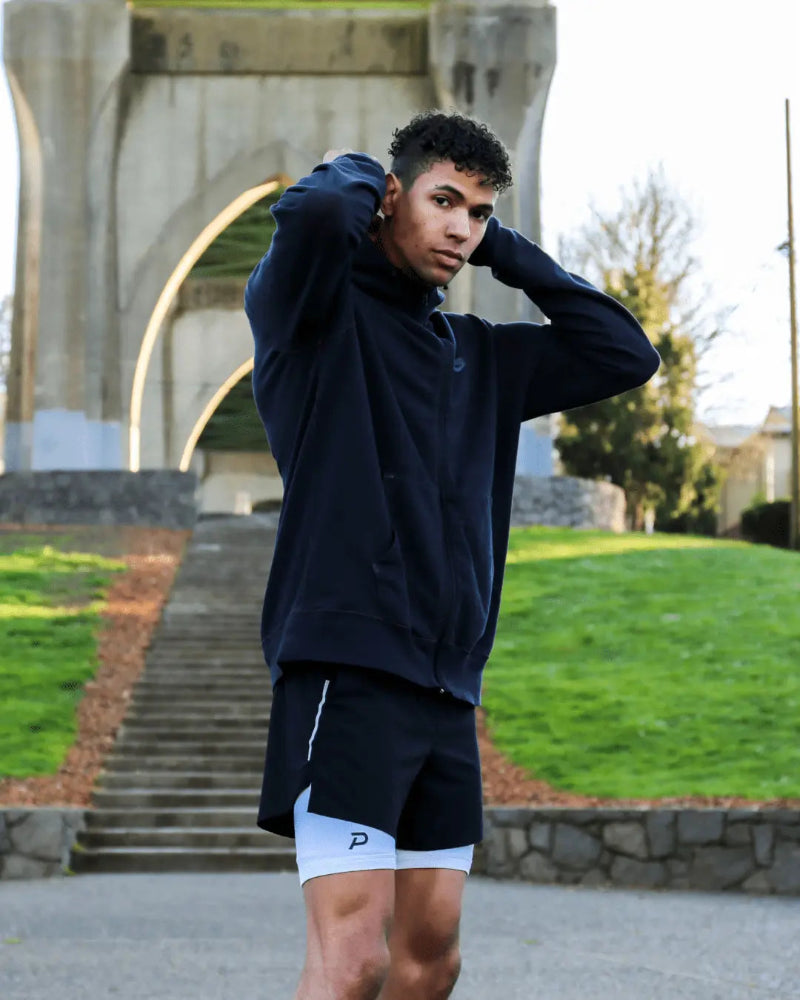 Athlete in an outdoor park wearing white Pacterra Middy compression shorts as a comfortable base layer under gym shorts, ideal for PNW outdoor training.