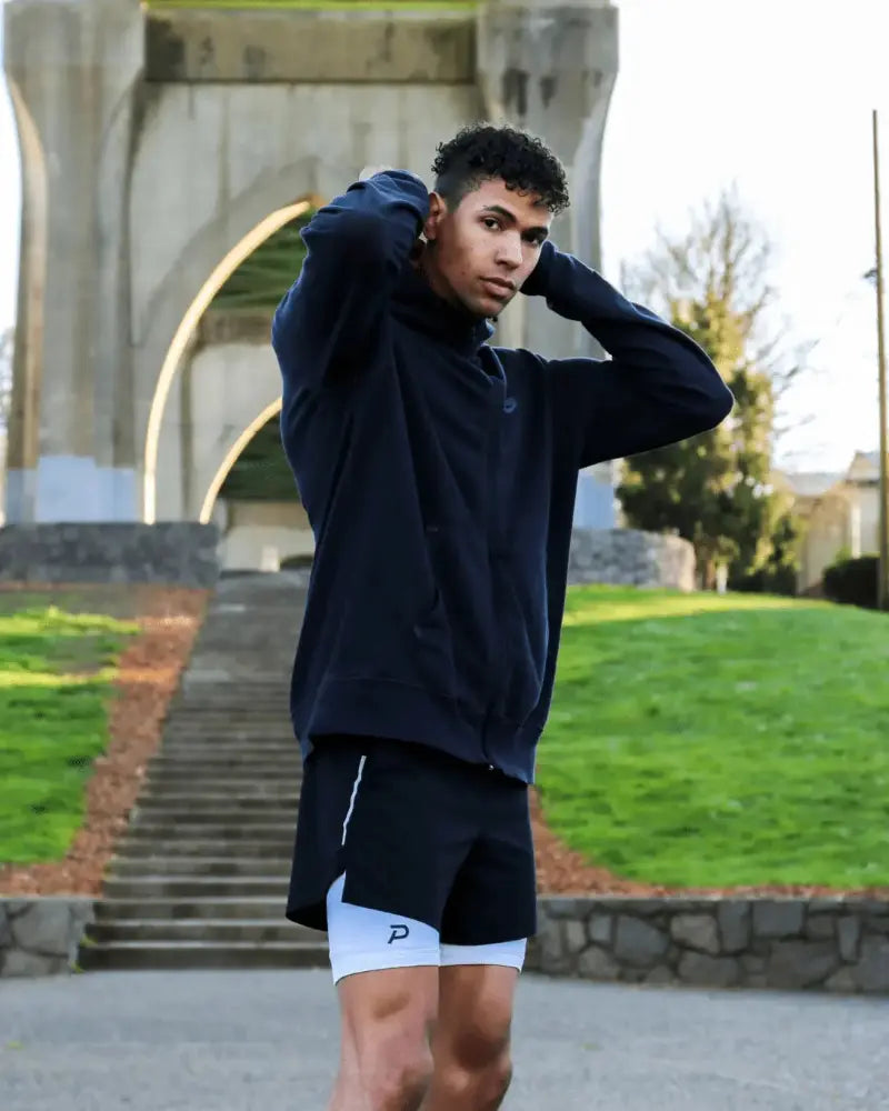 Athlete in an outdoor park wearing white Pacterra Middy compression shorts as a comfortable base layer under gym shorts, ideal for PNW outdoor training.